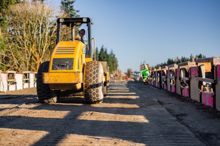 F200 roller grading behind MSE wall