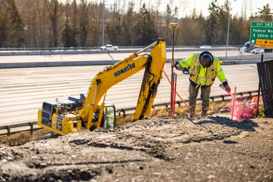 F200 excavator working alongside survey crew