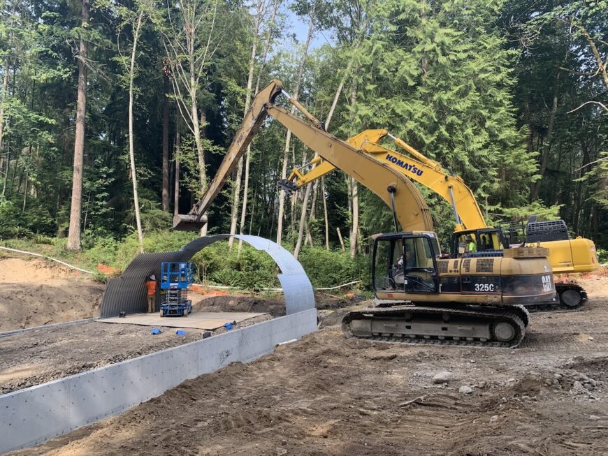 Habour Reach two excavators installing steel pipe culvert