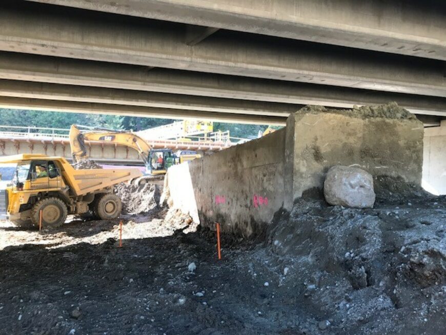 Mini haul truck working below I90 getting loaded with dirt