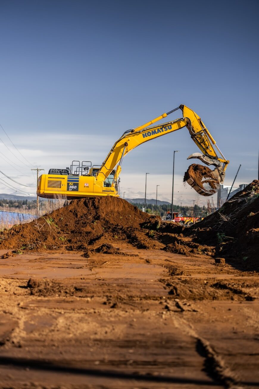 Project Roxy excavator perched on pile of dirt with Mt Rainier in the background