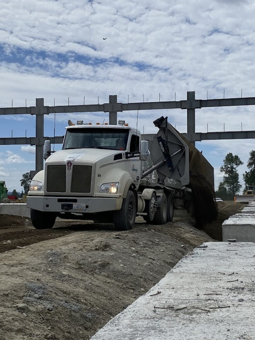 Project Roxy side dump truck dumping dirt