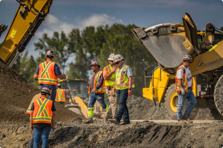 men working in safety vests with tractors