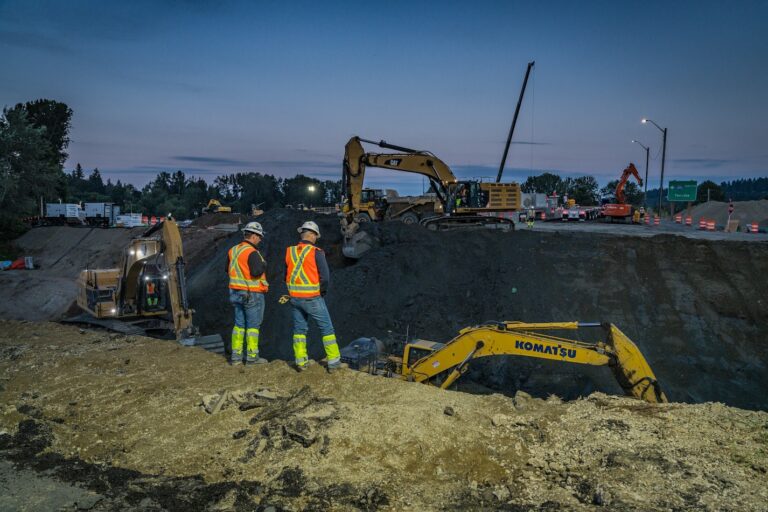 Workers looking over excavation for culvert installation